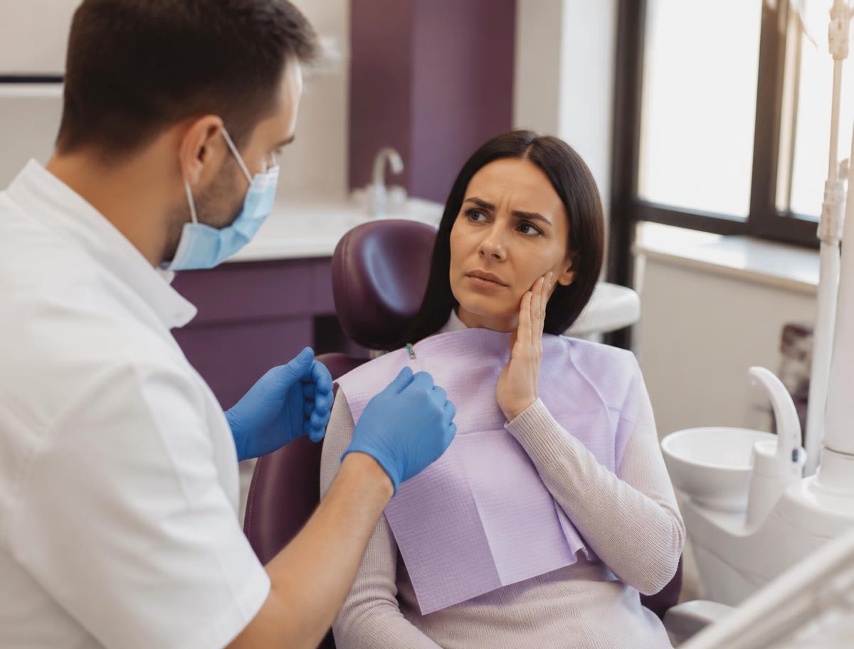 Dentist and assistant carefully treating a patient during an urgent dental visit
